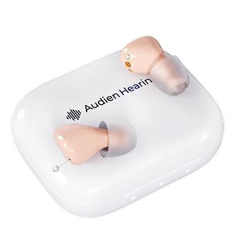 Pair of pink hearing aids in a white case with 'Audien Hearing' branding.